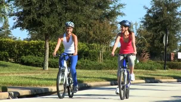 白人の女性の友人郊外の道路上の自転車 — ストック動画