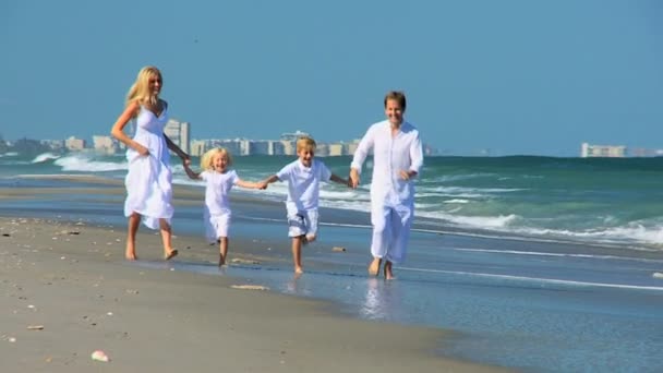 Glückliche kaukasische Familie läuft am Strand — Stockvideo