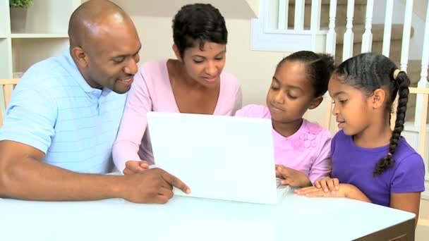 Trotse etnische ouders kijken dochters met behulp van laptop — Stockvideo