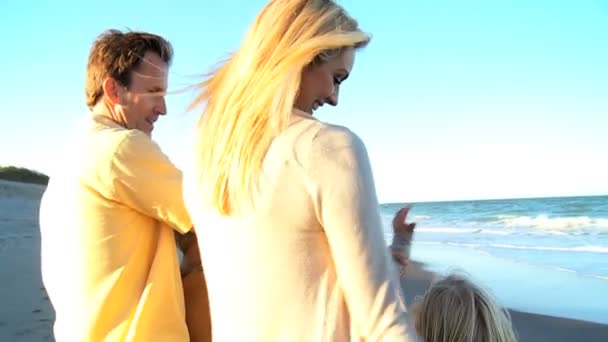 Счастливая молодая семья на пляже — стоковое видео