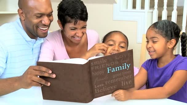 Familia étnica joven con álbum de fotos — Vídeos de Stock