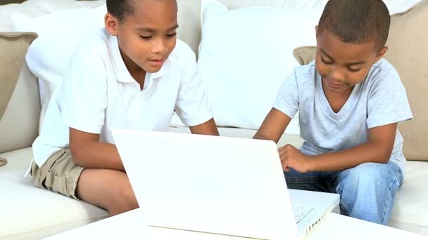 Meninos étnicos com laptop no sofá — Vídeo de Stock