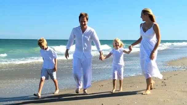 Feliz familia caucásica caminando en la playa — Vídeos de Stock