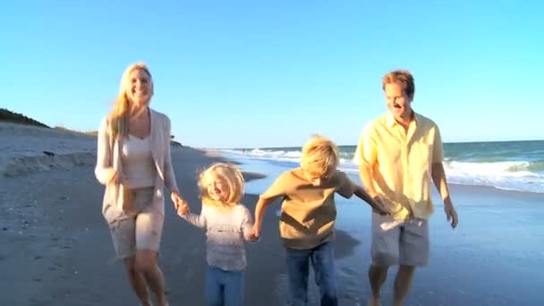 Jovem família caucasiana pulando na praia — Vídeo de Stock