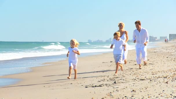 Joven familia caucásica corriendo en la playa — Vídeos de Stock