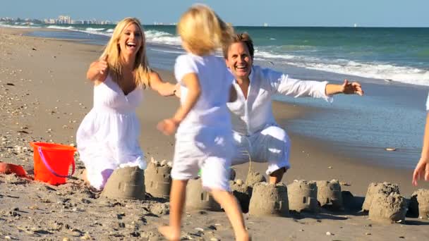 Kleine Kinder rennen zu Eltern am Strand — Stockvideo