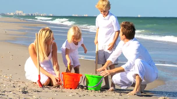 Kaukasische familie gebouw zand kastelen — Stockvideo