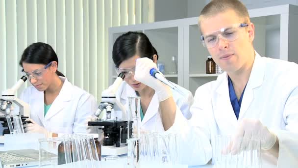 Tres estudiantes de medicina que estudian en el laboratorio del hospital — Vídeo de stock