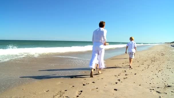 Jeune famille caucasienne courir sur la plage — Video