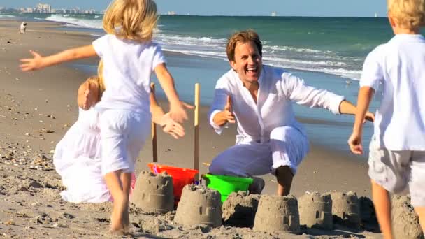 Niños corriendo en la playa a los padres — Vídeo de stock