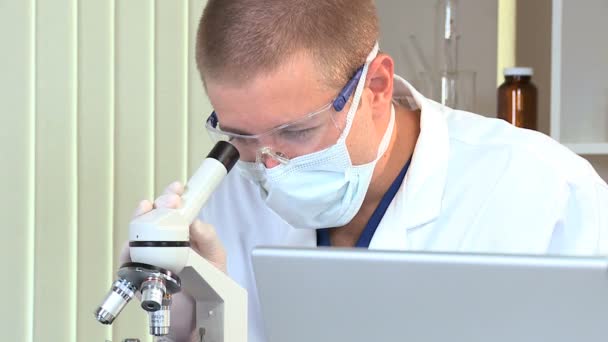 Mužské student medicíny s mikroskopem a laptop — Stock video