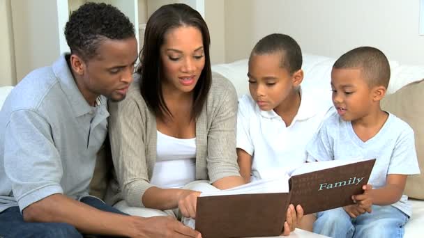 Jonge etnische gezin kijken naar foto album — Stockvideo