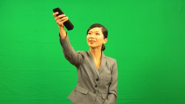 Asian Business Female Remote Control Green Screen — Stock Video