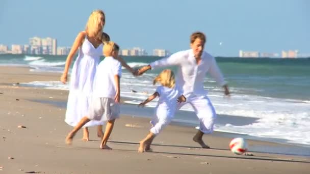 Καυκάσιος οικογένεια κλωτσούν μια μπάλα στην παραλία — Αρχείο Βίντεο