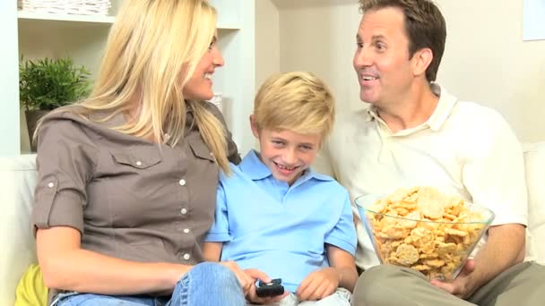 Film atıştırmalıklar ile birlikte izlerken genç aile — Stok video