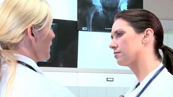 Médicos caucásicos examinando resultados de rayos X — Vídeo de stock