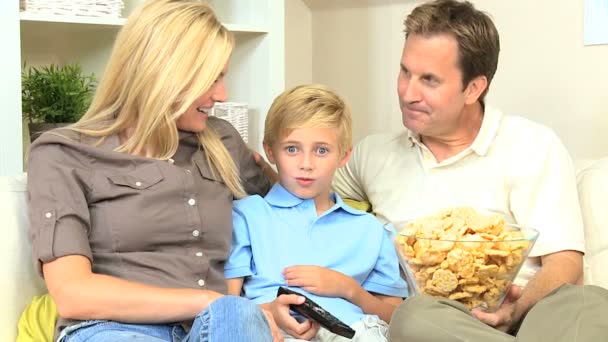 Atractiva familia disfrutando de TV & Snack Food — Vídeo de stock