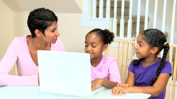 Madre etnica che guarda le figlie usando il computer portatile — Video Stock