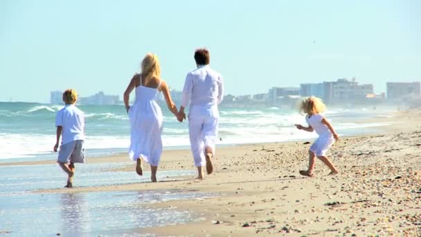 Giovane famiglia caucasica che corre sulla spiaggia — Video Stock