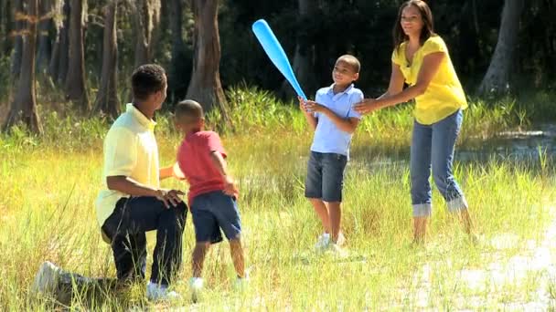 Actieve etnische familie spelen honkbal in park — Stockvideo