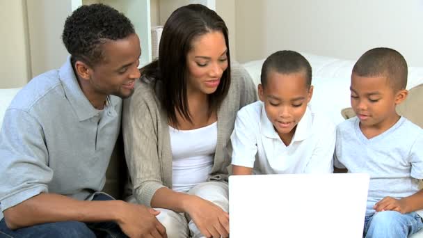 Pais étnicos assistindo filhos usando laptop — Vídeo de Stock