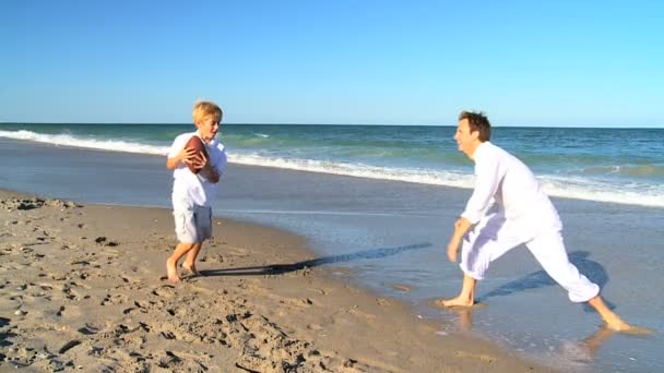 Блондинка батько і син на пляжі грає м'яч — стокове відео