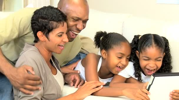 Молодые родители наблюдают за детьми с помощью беспроводного планшета — стоковое видео