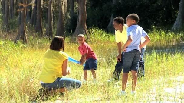 Piccolo ragazzo etnico che pratica il baseball con la sua famiglia — Video Stock