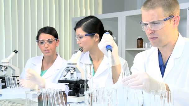 Трое студентов-исследователей, работающих в медицинской лаборатории — стоковое видео