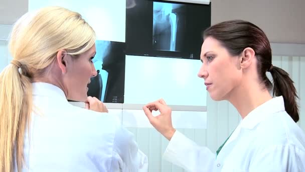 Técnicas femeninas examinando escáneres de rayos X — Vídeo de stock