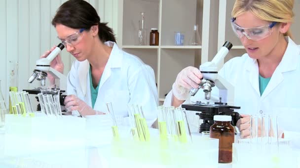 Pesquisadoras médicas femininas usando microscópios — Vídeo de Stock