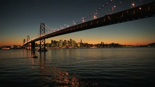 Aerial sunset view under the illuminated Oakland Bay Bridge, San Francisco, USA — Stock Video