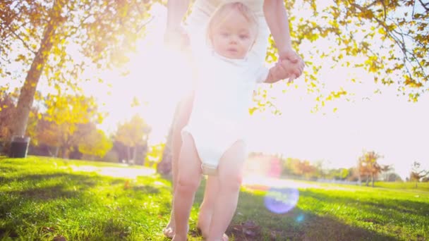 Bébé heureux soutenu par sa mère alors qu'elle pratique la marche — Video