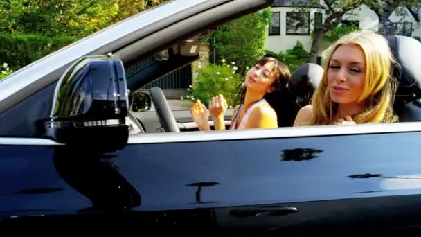 Chicas jóvenes conduciendo en coche abierto superior — Vídeo de stock