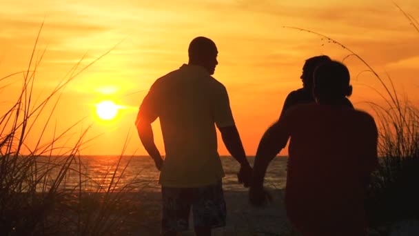 Gün batımında sahilde aile — Stok video