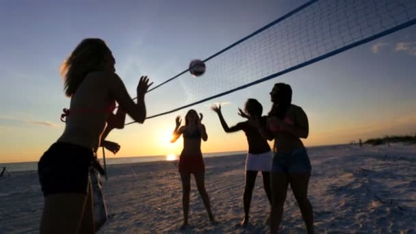 La gente al atardecer jugando voleibol — Vídeos de Stock