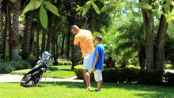 Pai ensinando filho jogando golfe — Vídeo de Stock