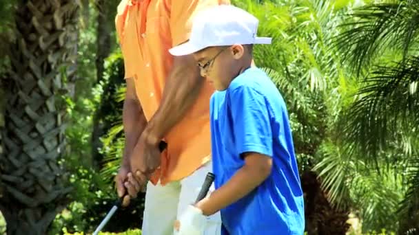 Отец учит сына играть в гольф — стоковое видео