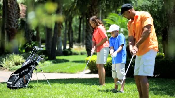 Familia practicando su swing de golf — Vídeo de stock