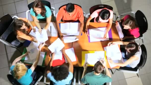 Подростки, сидящие с преподавателем колледжа — стоковое видео