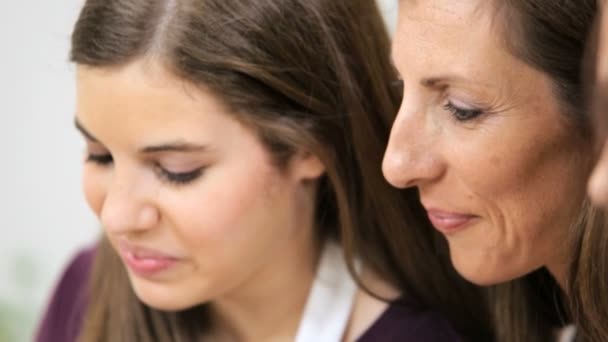 Madre usando la tableta inalámbrica con hijas adolescentes en la cocina casera — Vídeos de Stock