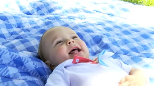 Śmiech dziecka chłopiec dywan leżący w parku na świeżym powietrzu — Wideo stockowe