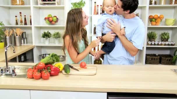 年轻的白人父母在家抱着男婴的厨房柜台 — 图库视频影像