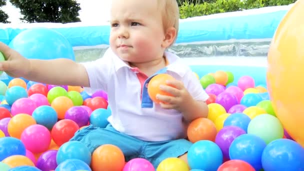 Caucásico bebé niño disfrutando de sí mismo en jugar bola de plástico piscina — Vídeos de Stock