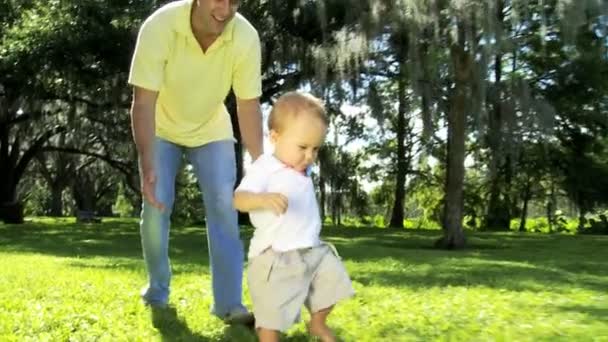 Trotse jonge Kaukasische vader met zijn lachende kleine jongen — Stockvideo