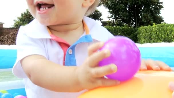 Enfant caucasien jouant à la balle à la piscine — Video