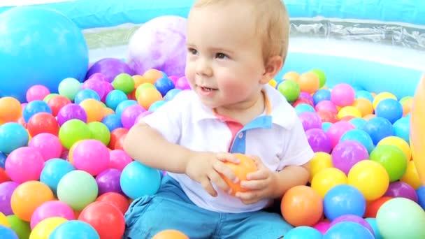 Lachen Kaukasische babyjongen met plezier met ouders spelen in multi gekleurd ballenbad — Stockvideo