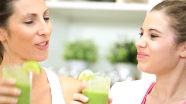 Caucasian mom and  pretty teenage daughter drinking blended organic vegetable smoothie before exercising — Stock Video