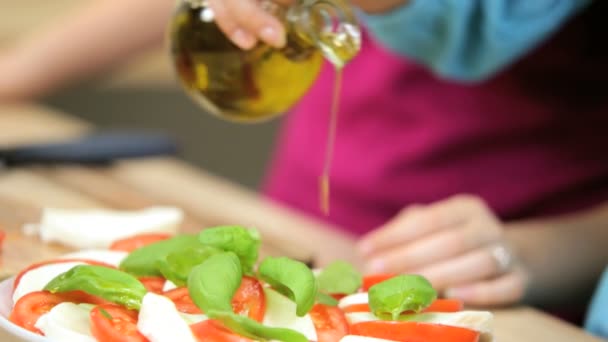Gros plan de la fille à la cuisine domestique arrosant huile d'olive extra vierge — Video