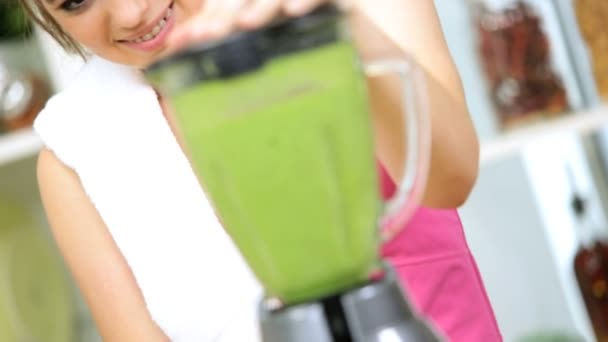 Young brunette girl  using electric blender to produce delicious healthy vegetable smoothie — Stock Video